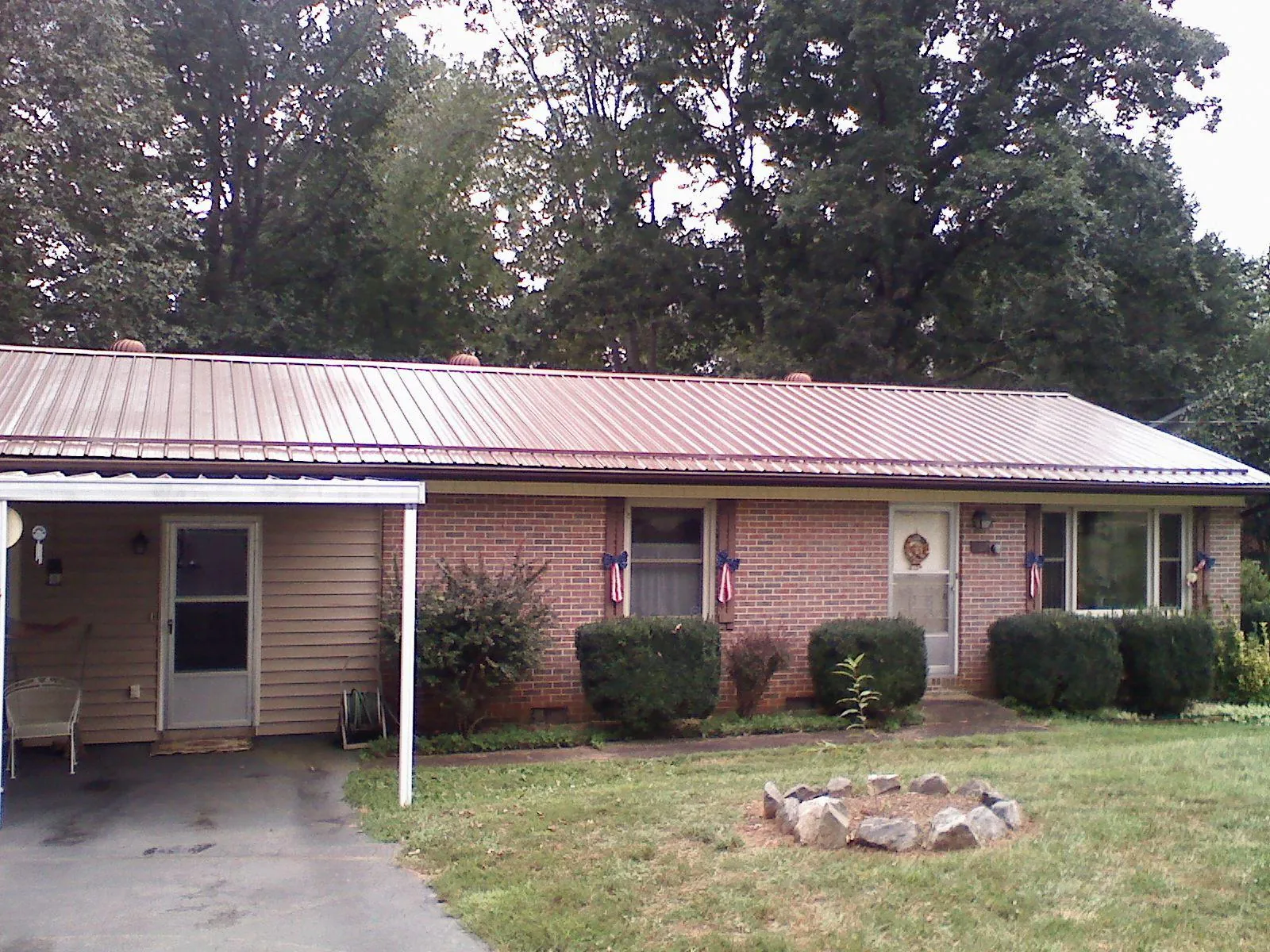 Bronze metal roof and carport on a brick ranch home — Roof Repair work by our crew in Eagle Bridge